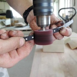 le mani di un uomo che lavora i bracciali in legno Paul Cortese